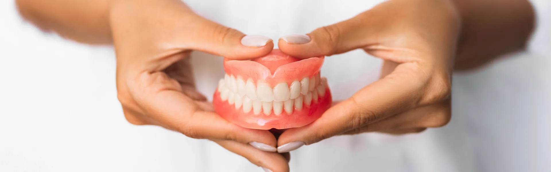 Dentist Holding Teeth Dentures in Hand