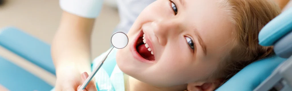 Child smiling during a dental exam for cavity detection